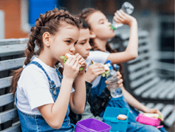 Three child eat, appetizing school lunch  Healthy school lunch: apple, juice, hamburger, vegetable,after education  