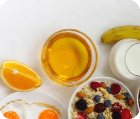 Healthy breakfast with muesli, fruits, berries, nuts, coffee, eggs, honey, oat grains and other on white background  Flat lay, top view, copy space for text, frame