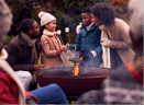Multi-Generation Family Having Fun Toasting Marshmallows In Autumn Garden Together