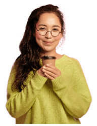 Portrait of attractive korean girl stands with takeaway coffee, enjoys caffeine beverage, looks with tender happy expression, has break, dressed in oversized green jumper drinks hot tea from paper cup