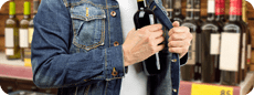 man in a supermarket stealing a bottle of champagne