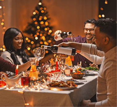 holidays, party and celebration concept - multiethnic group of happy friends having christmas dinner at home and drinking wine
