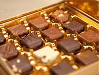 Golden box of fine handmade chocolates in different colors and kinds.