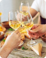 Hands with white wine glasses. Dinner and celebration