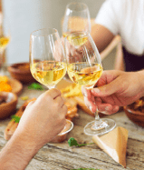 Hands with white wine glasses. Dinner and celebration